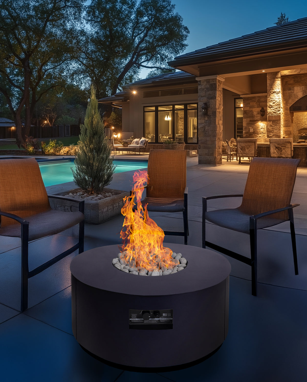 Warming Trends AON round fire table in Black by a pool