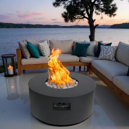 Warming Trends AON round fire table in Charcoal on a lakeside patio