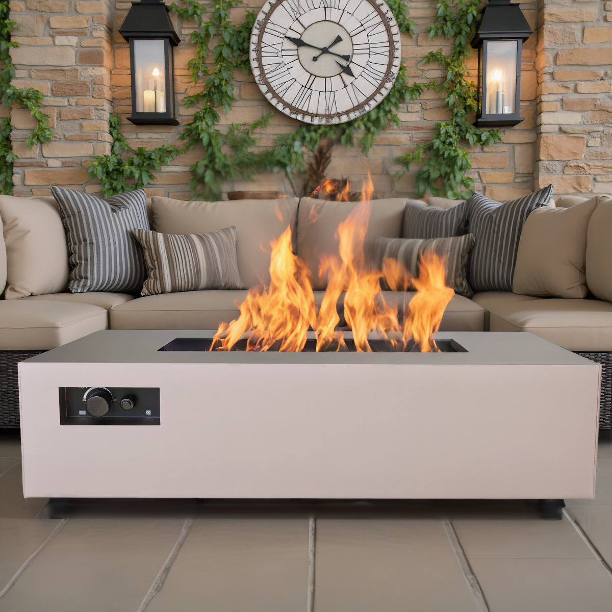 Warming Trends AON rectangular fire table in Sand Pebble by a stone wall